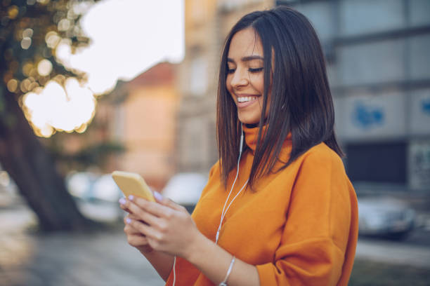 istock Young woman using phone in the park 1058824302
