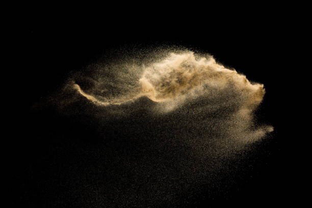 istock Golden sand explosion isolated on black background. Abstract sand cloud. 1058828180