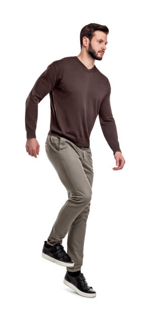 istock A serious looking man in casual clothes walks down invisible stairs on a white background. 1058829366