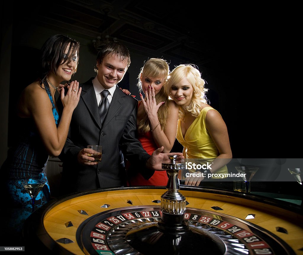 Roulette in Casino four people in casino playing roulette Casino Stock Photo