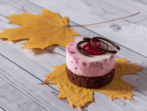 Fresh cherry cake round shape on a light wooden background. Biscuit cake on a wooden table.