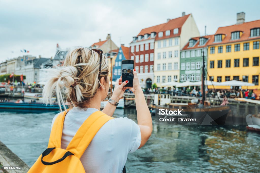 Traveling to Copenhagen - tourist in Nyhavn Traveling to Copenhagen Copenhagen Stock Photo