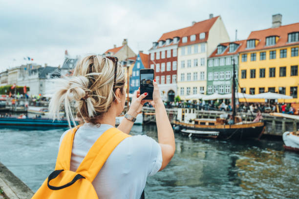 Traveling to Copenhagen - tourist in Nyhavn Traveling to Copenhagen women taking selfies photos stock pictures, royalty-free photos & images