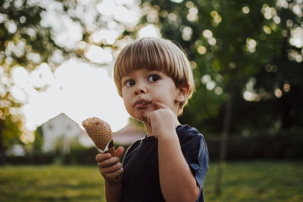istock Happy boy with an ice cream outside 1058841128