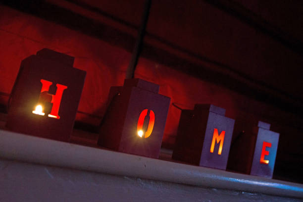 istock Domestic candle holders with letter cut outs spelling HOME 1058845358