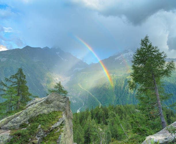 landscape with colorful rainbow in the mountains during a light summer rain