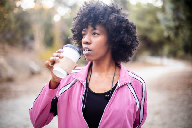 istock Young Black Woman Walking with Coffee 1058846838
