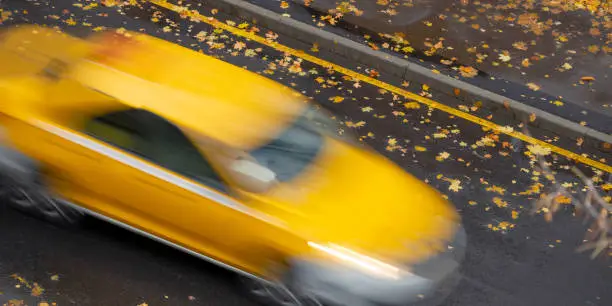 Yellow car in motion in blurred focus. Yellow line as a sign of a ban stop for cars.