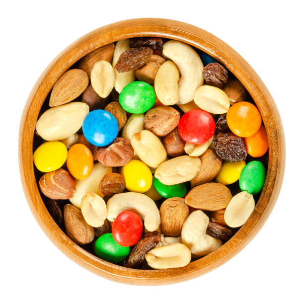 istock Trail mix in wooden bowl over white 1058852286
