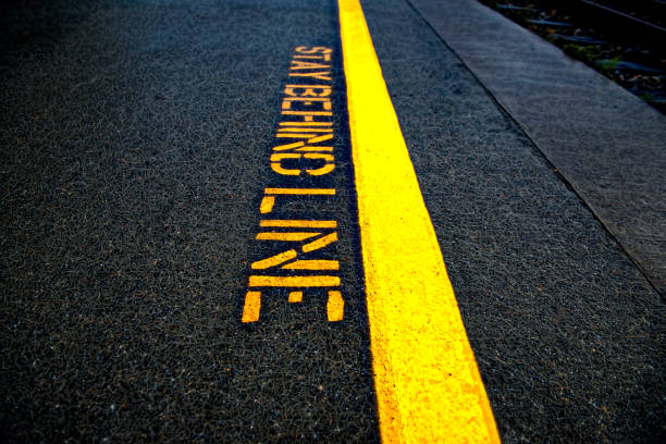 istock Stay Behind Line Stenciled on Black Pavement 1058856768
