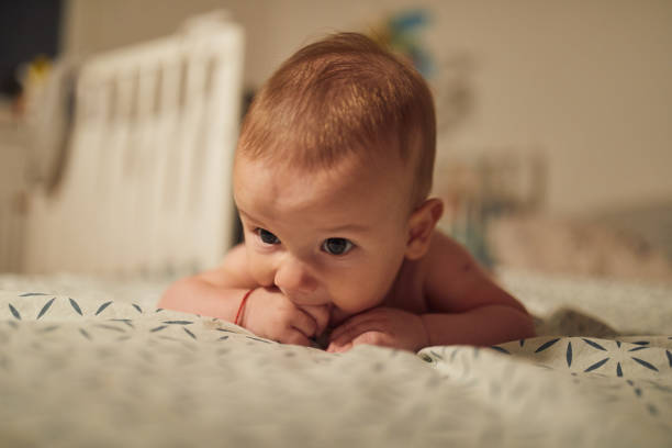 istock 4 months old baby laying on bed 1058857056