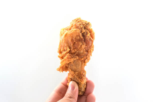 istock Hand hold fried chicken isolated on white 1058859104