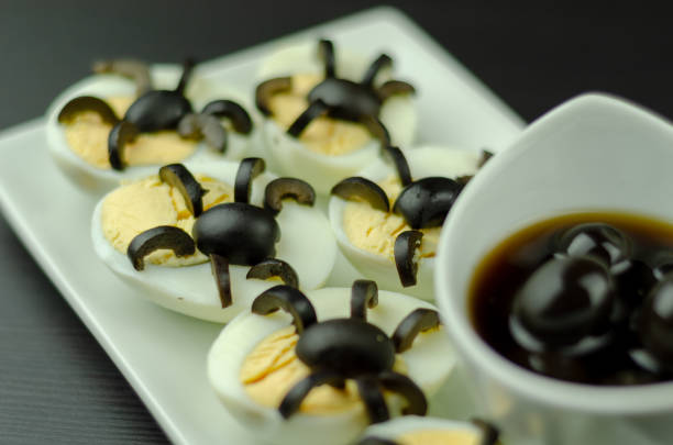 istock funny snack with olive spiders on egg halves for halloween party, 1058864516