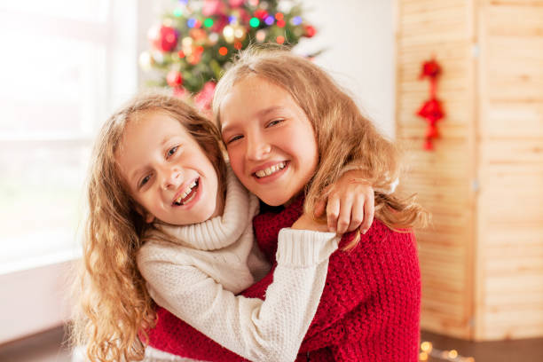 istock Two happy girl near christmas tree 1058868064
