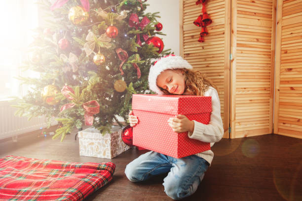 istock Child with gift near christmas tree 1058868268