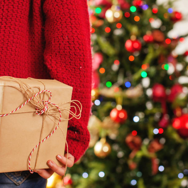 istock Child near the Christmas tree with a gift behind 1058868916