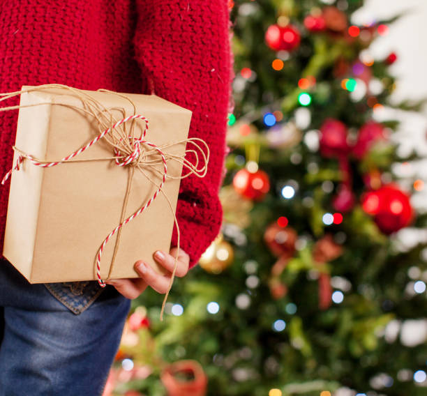 istock Child near the Christmas tree with a gift behind 1058868918