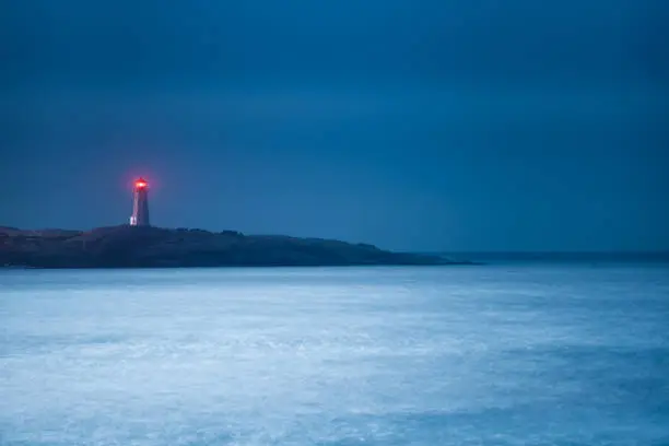 Photo of Moonlit nighttime lighthouse