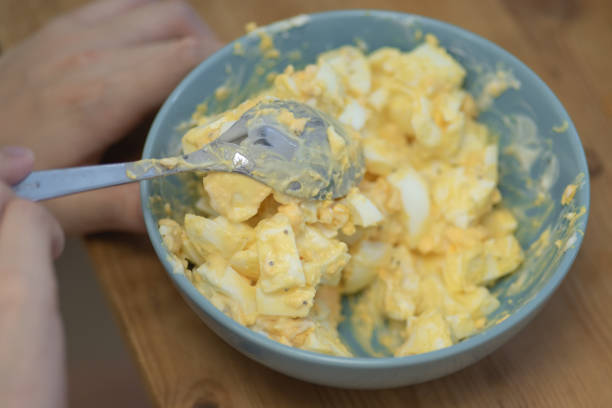 istock Making Egg Mayonnaise in a bowl. Mixing diced hard-boiled eggs with mayo. 1058877822