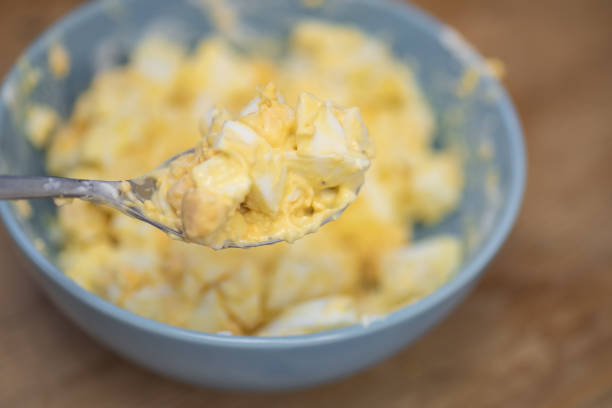 istock Making Egg Mayonnaise in a bowl. Mixing diced hard-boiled eggs with mayo. 1058877890