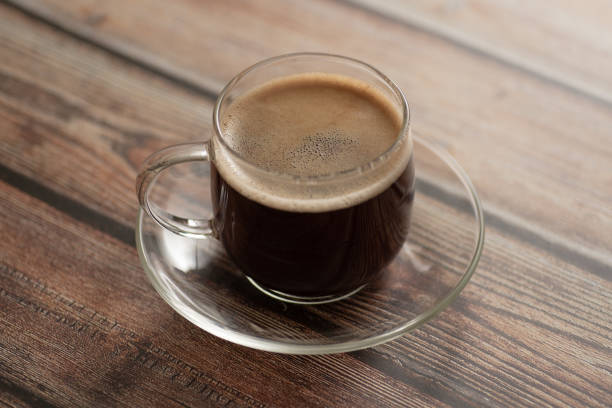istock Black coffee in a glass cup on an old wooden surface. 1058877982