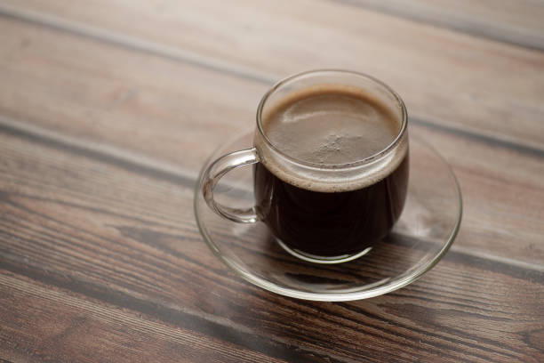istock Black coffee in a glass cup on an old wooden surface. 1058878022