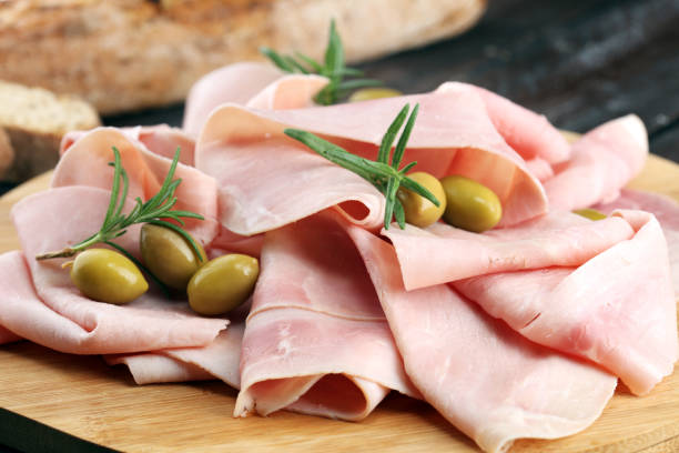 istock Sliced ham on wooden background. Fresh prosciutto. Pork ham sliced. 1058880754