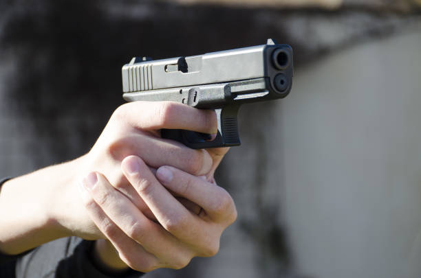 istock A gun in the hands of a man ready for a shot. 1058880924