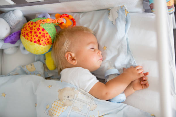 istock Cute little baby boy, sleeping with bottle with formula milk 1058881756