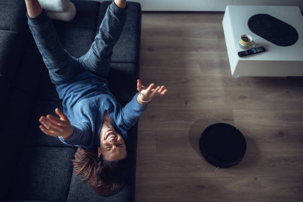 istock Happy Young Woman Using Robotic Cleaner 1058884568