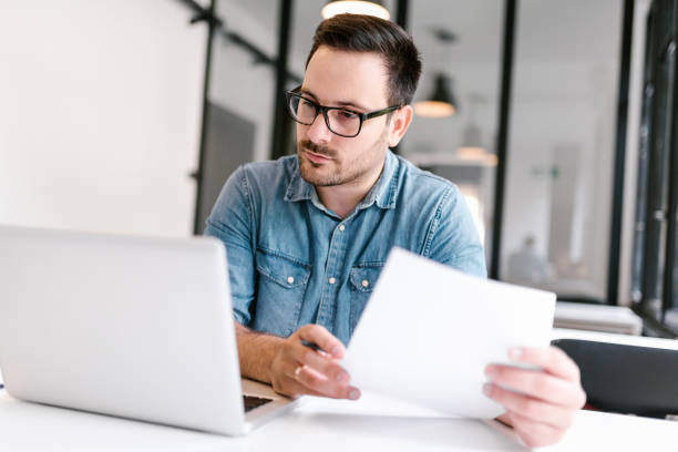 istock Young man working in modern office. Close-up. 1058885210