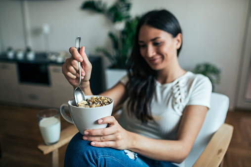 A woman holds the bowl with muesli