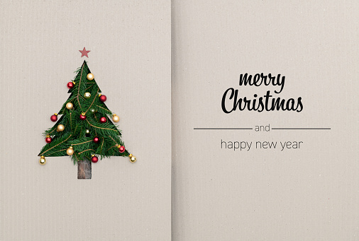 Merry Christmas and happy new year greetings in vertical top view cardboard with natural eco decorated christmas tree pine.Ecology concept.Xmas winter holiday season social media card background.