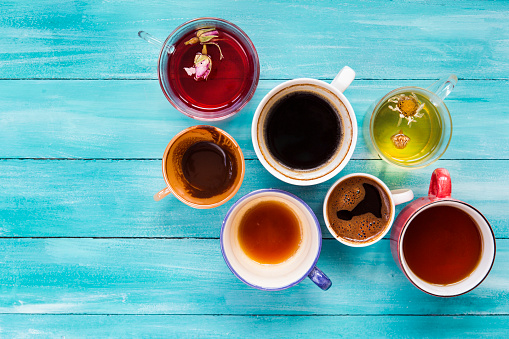 Mugs with drinks on wood