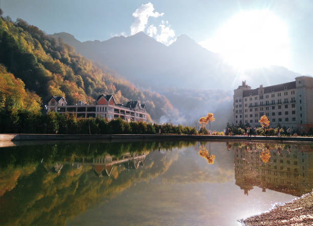 Rosa Khutor beach Panoramic scenic view of Rosa Khutor beach in Krasnaya polyana (Sochi, Russia). Water reflection of mountains and hotels in famous ski resort at summer autumn day sochi photos stock pictures, royalty-free photos & images