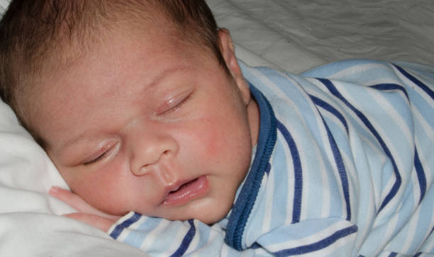 istock two weeks old newborn baby boy smilleing while sleeping 1058910400