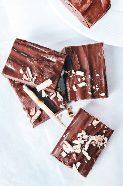 istock Pieces of chocolate brownies decorated with chocolate splitters. Directly above, white background, isolated. 1058914992