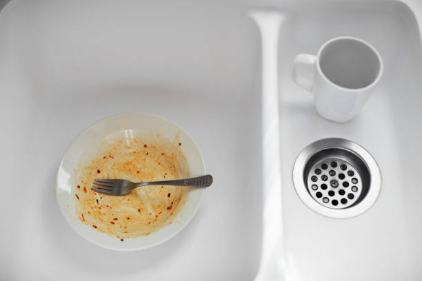 istock Dirty dish and a mug in the sink 1058921962