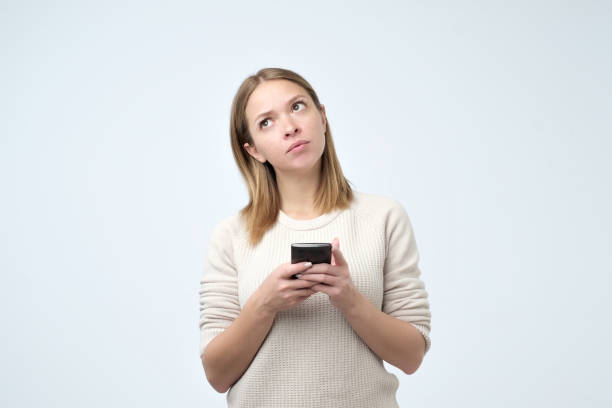 istock Split up message for boyfriend. Young cute attractive woman is writing some text or using a smart phone 1058923508