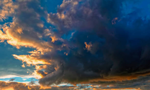 istock Blue sky with gold clouds - dramatic sunset, beautiful natural background. Setting sun illuminates the clouds. 1058923896