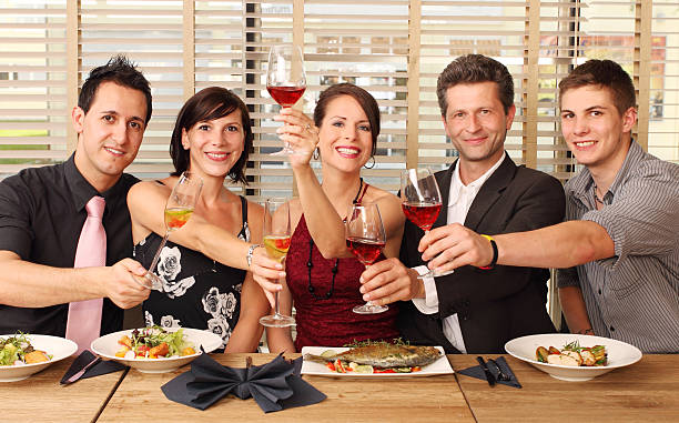 friends in a restaurant - clink glasses stock photo