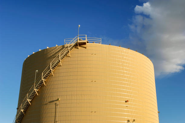 Large oil well storage tank, below of a cloud filled sky, used to store some of the oil pumped from the Cymric Oil Field. \n\nTaken in the Cymric Oil Field in Kern County, California, USA.