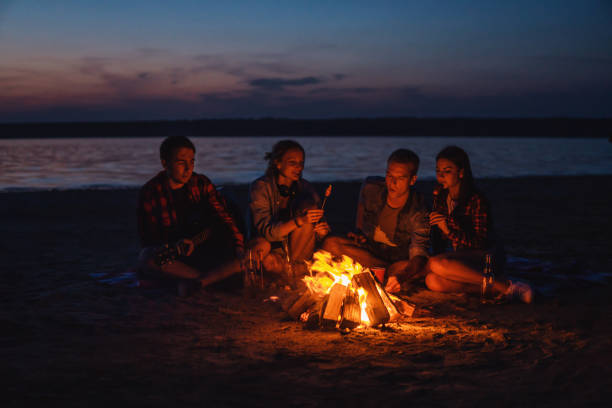 istock young friends have picnic with bonfire on the beach 1058938564