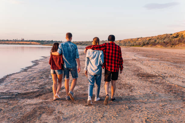 istock friends on beach together walking during sunset 1058941264