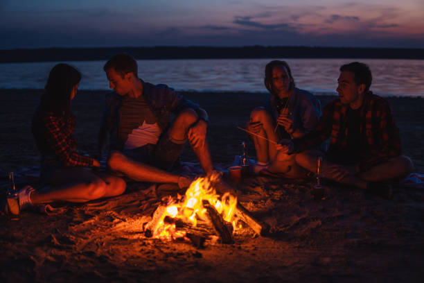 istock young friends have picnic with bonfire on the beach 1058942972