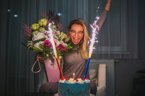 Caucasian woman with flowers and  her birthday cake