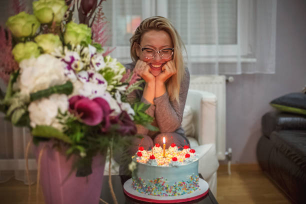 Caucasian woman with flowers and  her birthday cake
