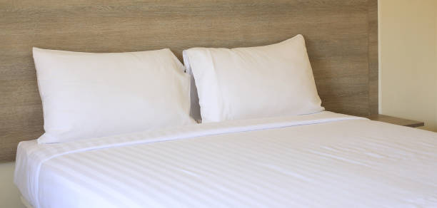 istock Close-up white pillows on bed in hotel. 1058955100