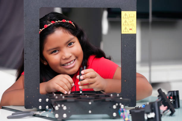 happy 8 year old girl building a 3d printer kit for summer engineering camp or class - child prodigy imagens e fotografias de stock