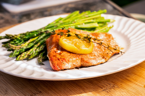 Beautiful salmon filet grilled and plated with lemon and asparagus